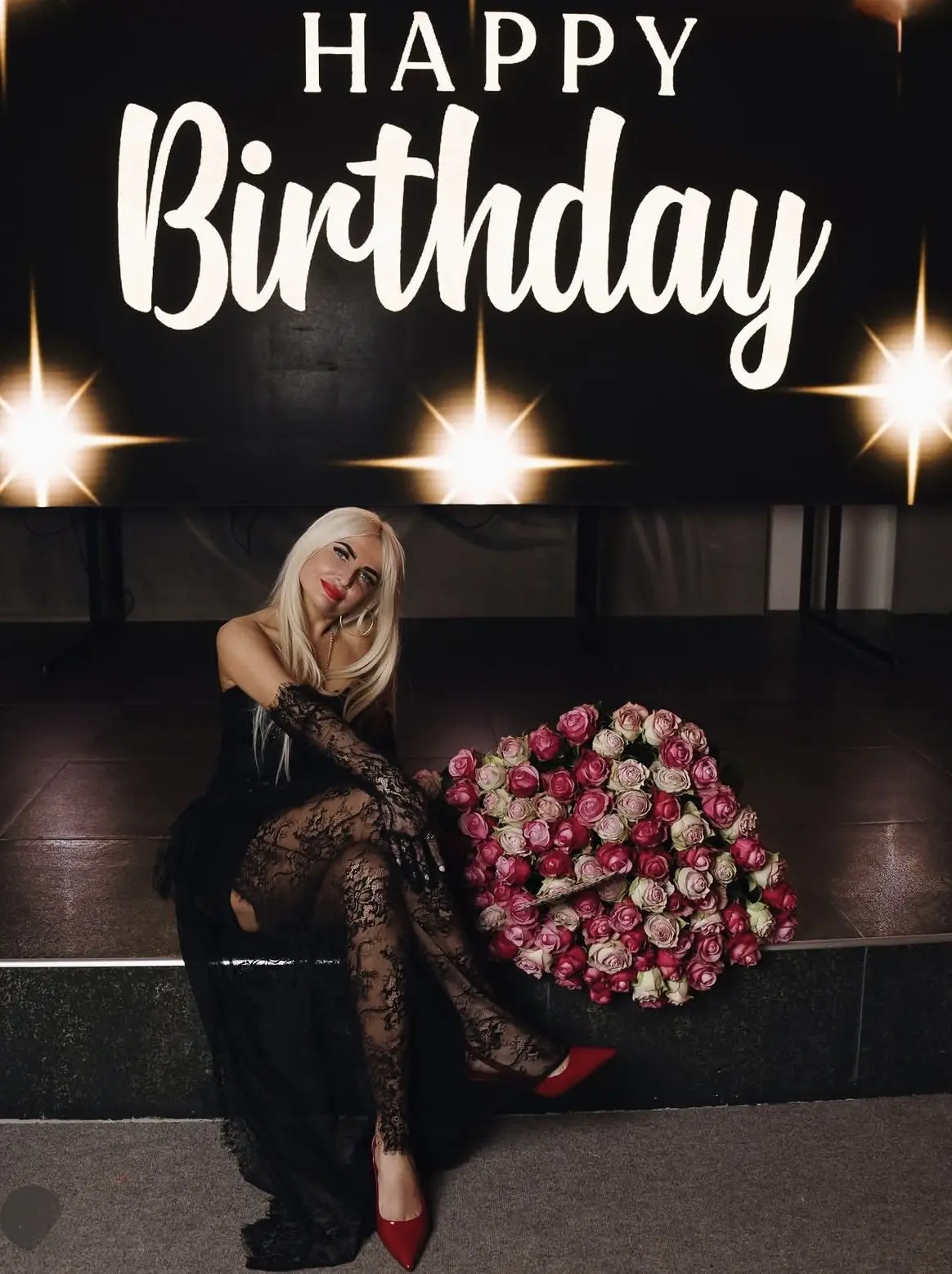 Именинница с букетом роз у LED-экрана с надписью Happy Birthday